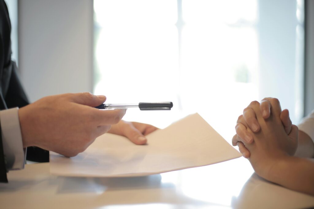 pexels-photo-3760067-3760067-1 Close-up of a contract signing with hands over documents. Professional business interaction.
