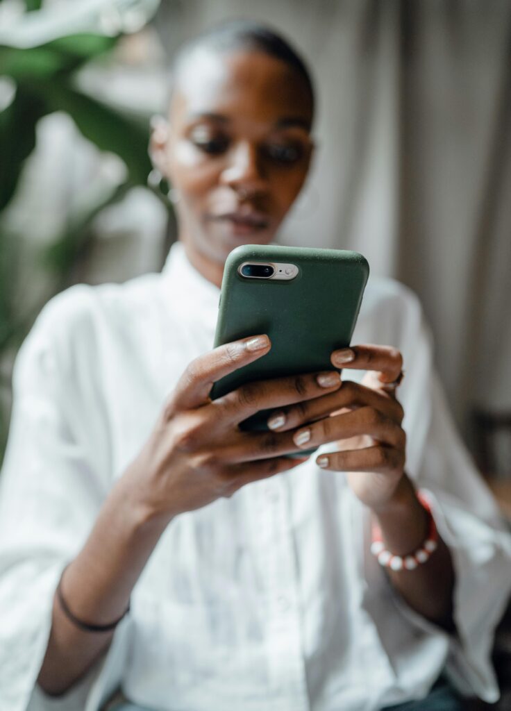 pexels-photo-4350099-4350099 A woman in a white blouse using her smartphone indoors, showing a thoughtful and calm mood.